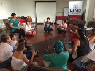 Colombian actor/director Daniel Rocha sits with women who play parts in the radio dramas