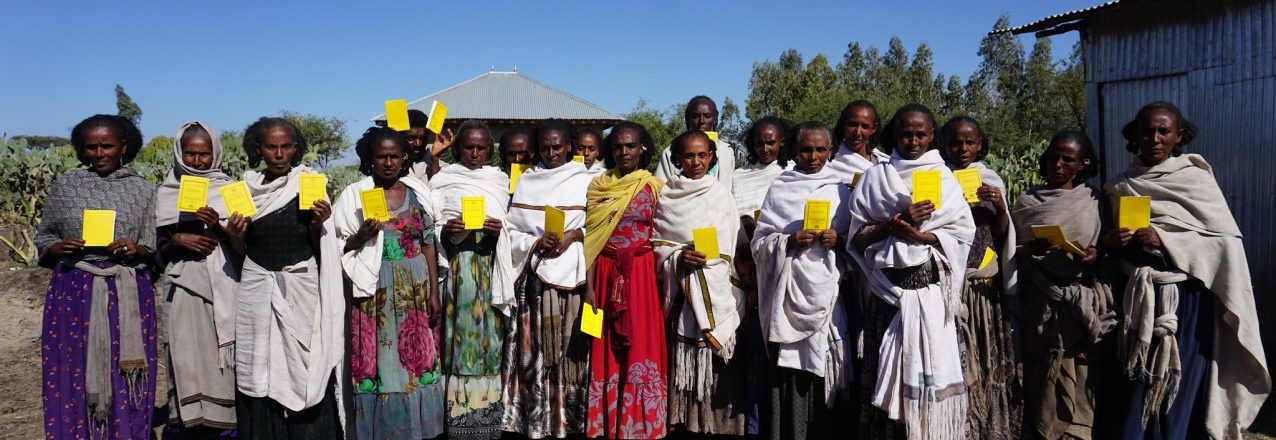 group of Ethiopian women standing holding land title documents