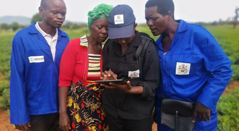 Margaret Dyson walks the boundaries of her land with data collector Alefa Kwenda and two CLC members from her community (in blue).