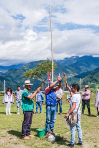 a group of indigenous people stand performing a ceremony