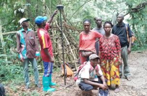 a group of people surveying in the forest