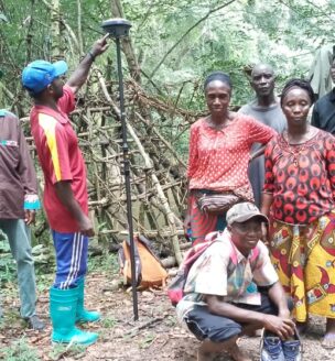 a group of people surveying in the forest