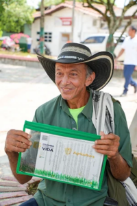 a man smiling and holding his land title