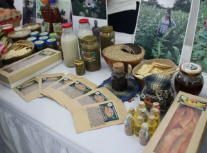 a market table display with seeds, milk, bread, and photos.