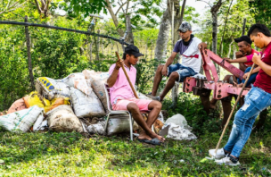 a group of people sitting together surrounded with farming supplies