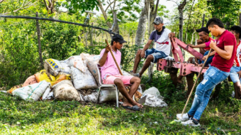 a group of people sitting together surrounded with farming supplies