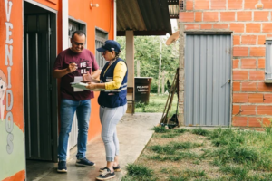 two people surveying land and writing on a notepad