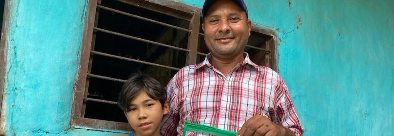 an adult man and child smiling, holding a certificate.