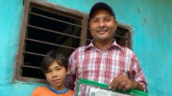 an adult man and child smiling, holding a certificate.