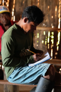 a man sat writing in a journal