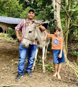 a man and child posing with a donkey